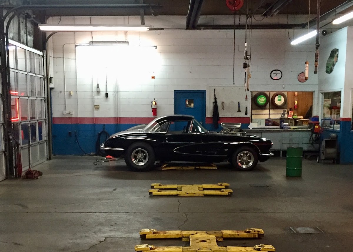 Inside the Marwood Tire shop bay with a classic black Corvette on the floor